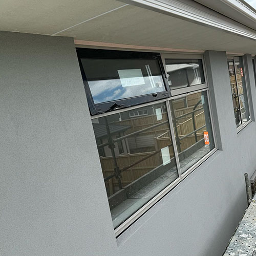 1-home-about-s4 Grey rendered wall around aluminium windows, seen at an angle